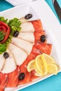 Mediterranean fish sliced Ã¢â¬â¹Ã¢â¬â¹salmon, tuna and trout with vegetables, greens, lemon and black olives Royalty Free Stock Photo